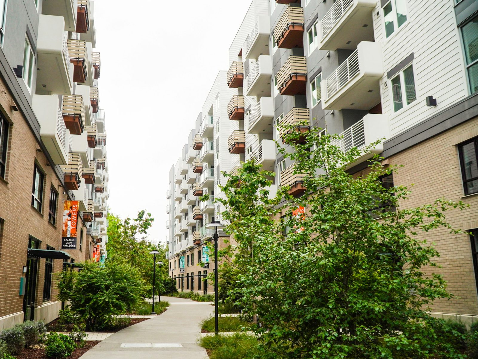 Condomínio residencial moderno com fachada de varandas e paisagismo